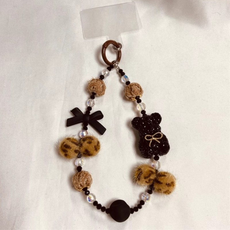 Lanière téléphone ECO – Marron et noir, ours et pompon Lanière téléphone ECO – Marron et noir, ours et pompon